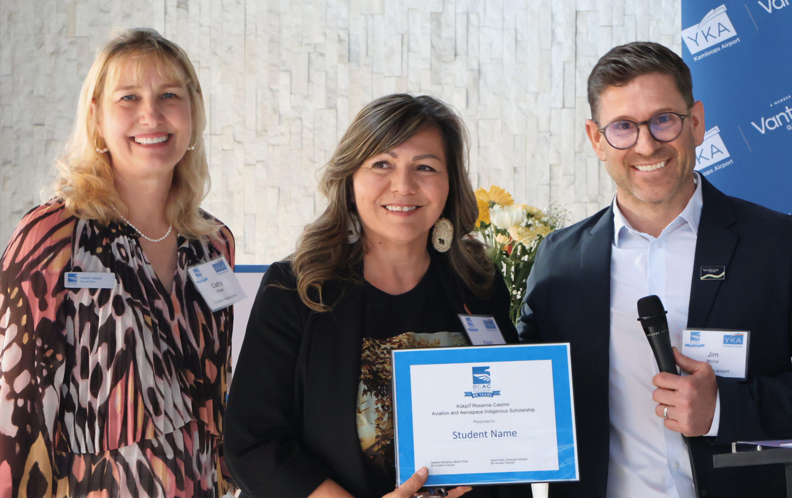 Cathy Press, Rosanne Casimir, and Jim Moroz holding the "Kúkpi7 Rosanne Casimir Aviation and Aerospace Scholarship"